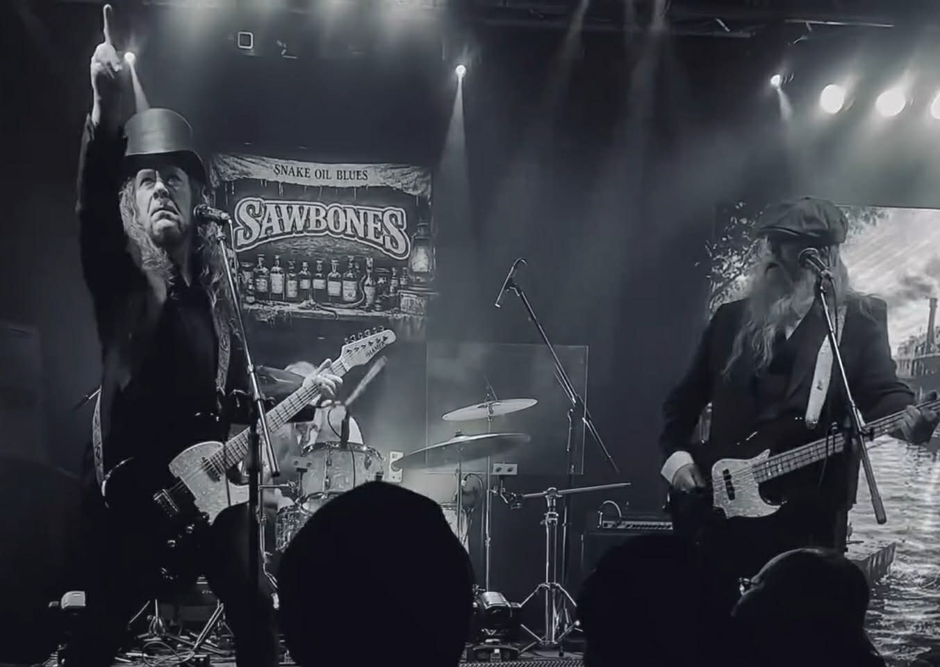 Sawbones performing together under theatrical stage lights